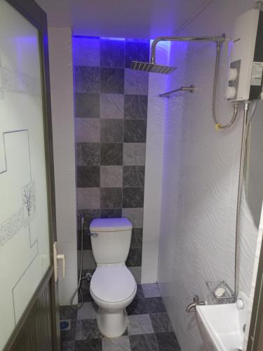 a bathroom with a toilet and a shower with purple lights at J&S lodging house in Baler