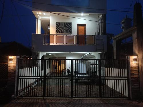 a house with a gate in front of it at night at J&S lodging house in Baler