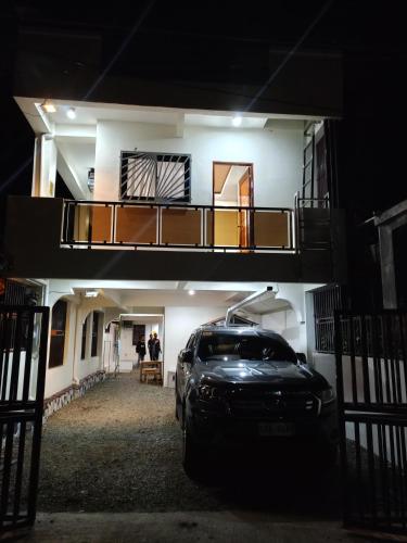 un coche aparcado delante de una casa por la noche en J&S lodging house, en Baler