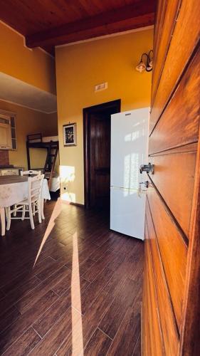 a room with a refrigerator and a dining room with a table at B&B Casale Pietrantica Tropea in Ciaramiti