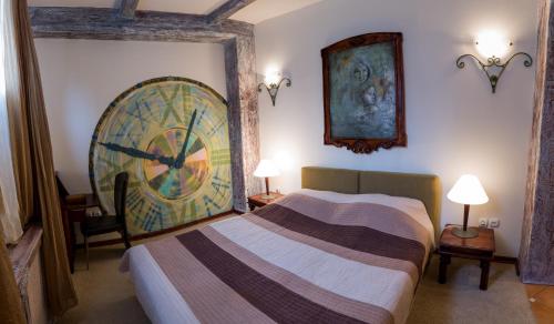a bedroom with a bed and a large clock on the wall at VILA STASEA in Smederevo