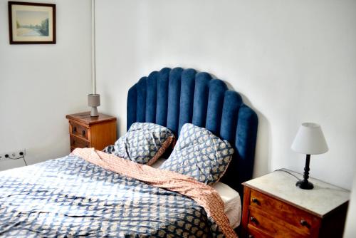 - une chambre avec un lit doté d'une grande tête de lit bleue dans l'établissement LES QUAIS DE NERAC, à Nérac