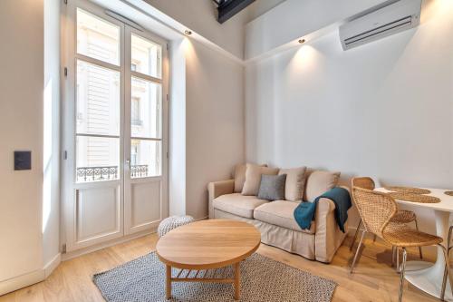 a living room with a couch and a table at Appartement Croisette Cannes centre in Cannes