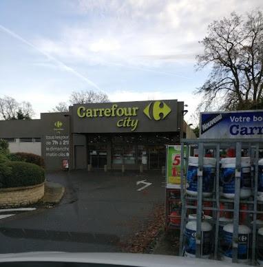 a store with a parking lot in front of it at location mobil-home le parc des roches in Saint-Chéron