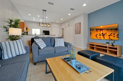 a living room with a couch and a table at Encantada Resort Vacation Townhomes by IDILIQ in Kissimmee