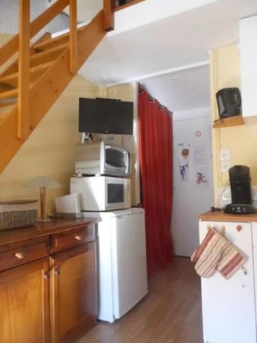 La cuisine est équipée d'un réfrigérateur blanc et d'un four micro-ondes. dans l'établissement Azur Sancy Skis aux pieds, à Le Mont-Dore