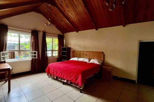 a bedroom with a bed with a red bedspread at Casa I’x (Jaguar) in San Juan La Laguna