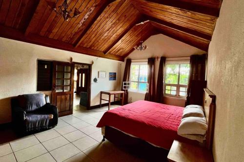 a bedroom with a red bed and a chair at Casa I’x (Jaguar) in San Juan La Laguna