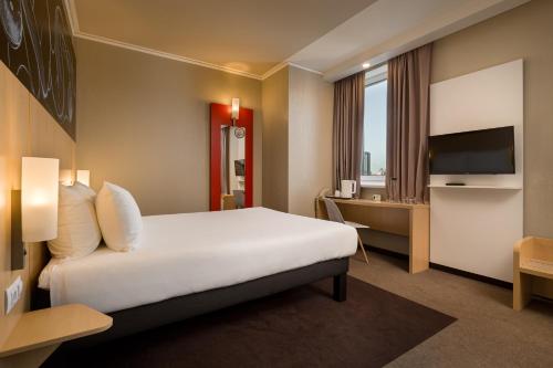a hotel room with a bed and a television at ibis Kyiv Railway Station in Kyiv
