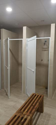 a room with a refrigerator and a wooden bench at Hostel Tropico 20 PDC in Playa del Carmen