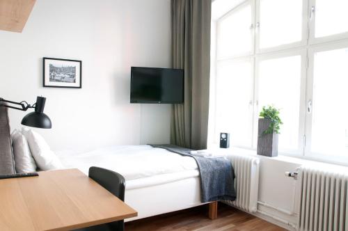 a bedroom with a bed and a tv on the wall at Continental Apartment Hotel Sundsvall in Sundsvall