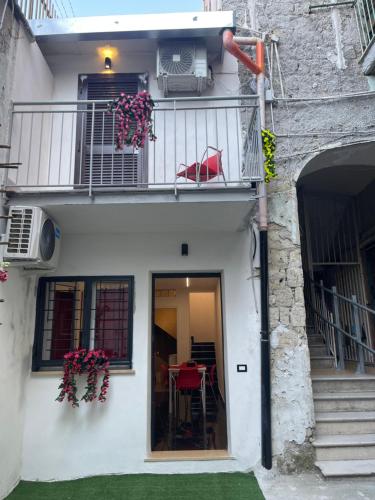 a white house with a balcony and a table and chairs at Lux House Naples Airport in Naples