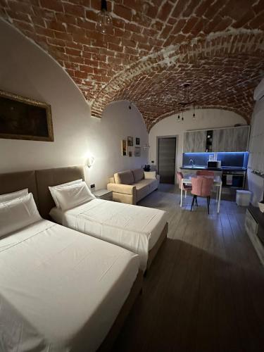 1 dormitorio con 2 camas y sala de estar con sofá en Residenza Zotaj Small appartament, en Casale Monferrato