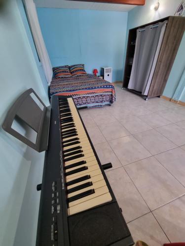 a room with a keyboard and a bed in it at VILLA AICHY in Rabi