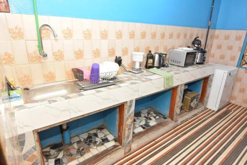 una cucina con lavandino e piano di lavoro di Résidence Les 6 Roses a Porto-Novo