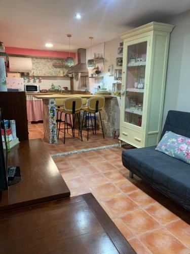 a living room with a couch and a kitchen at Cueva Colorin Alloza. in Alloza
