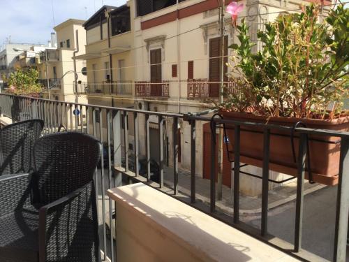 a balcony with two chairs and a pot of plants at Dimora Gentile in Conversano