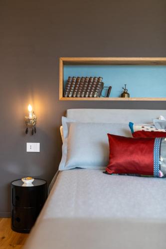 a bedroom with a bed with a red pillow and a shelf at Cascina Portinale 8 in Alba