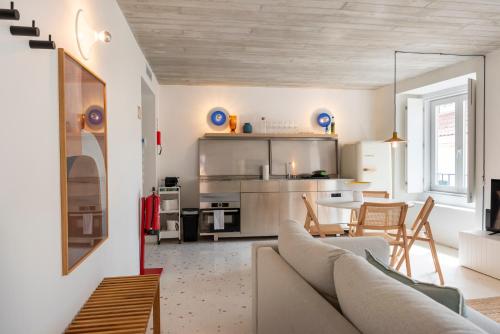 a living room with a couch and a kitchen at A Escada - Alfama Design Apartments in Lisbon