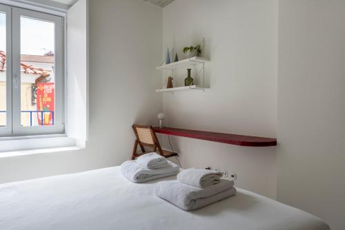 a room with two towels on a bed with a window at A Escada - Alfama Design Apartments in Lisbon