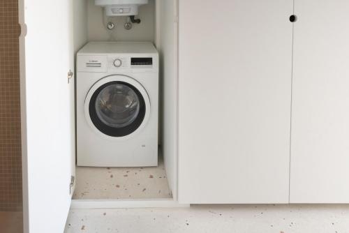 a washer and dryer in a white room at A Escada - Alfama Design Apartments in Lisbon