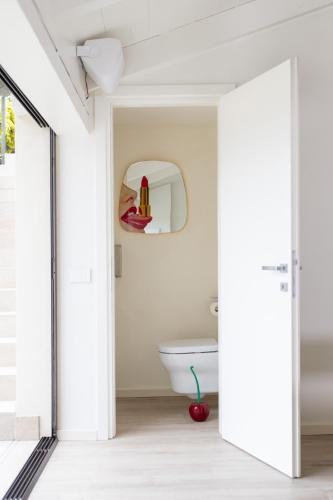 a bathroom with a white toilet and a mirror at Cascina Portinale 8 in Alba