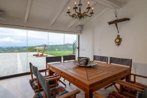a dining room with a wooden table and views of the water at Cascina Portinale 8 in Alba