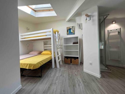 a bedroom with a bunk bed with a yellow bedspread at Maison de village, centre historique in Sérignan