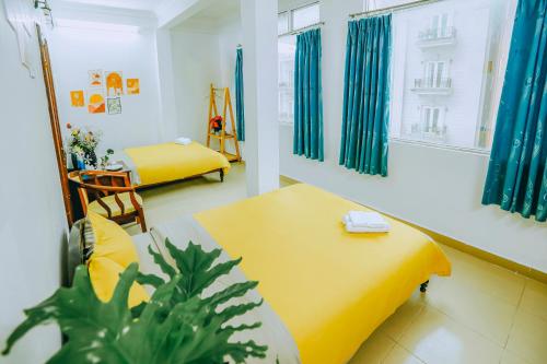 a room with a yellow bed and a table at Wealth Pearl Dalat Hotel in Da Lat