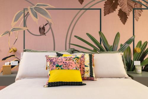 un letto con cuscini e parete rosa di Cascina Portinale 8 ad Alba