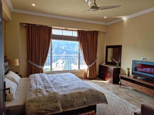 ein Schlafzimmer mit einem Bett und einem großen Fenster in der Unterkunft SK Lounges Bhurban in Bhurban