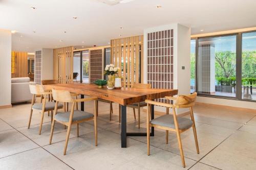 a dining room with a wooden table and chairs at Tierra Residences in Bangkok