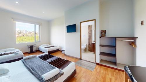 a bedroom with a large bed and a bathroom at Hotel Villa Colonia in Marinilla