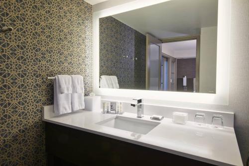 a bathroom with a white sink and a mirror at Detroit Marriott Troy in Troy