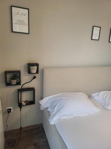 a bedroom with a bed with white sheets and a lamp at Sleep and drive cosy in Sarajevo