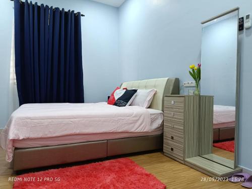 - une chambre avec un lit et un miroir dans l'établissement Loving Homestay, à Kuantan