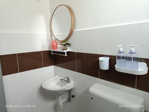 La salle de bains est pourvue d'un lavabo et d'un miroir. dans l'établissement Loving Homestay, à Kuantan