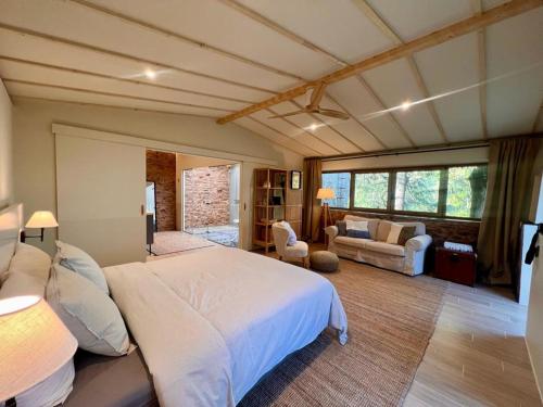a bedroom with a bed and a living room at Casa Fundeira - Quinta dos Esconhais in Castanheira de Pêra