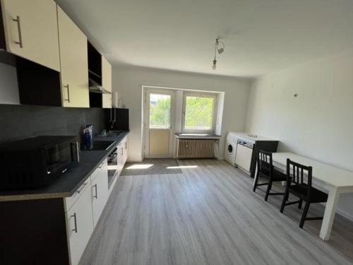 cocina grande con armarios blancos y suelo de madera en Luxembourg House en Sanem