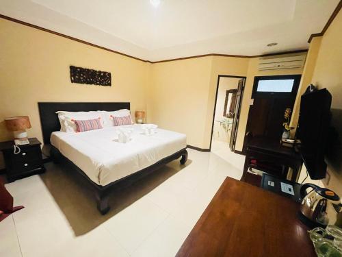 a bedroom with a large bed and a mirror at Na Thapae Chiangmai Hotel in Chiang Mai