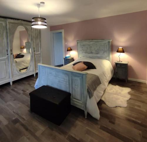 a bedroom with a bed and a large mirror at Gîte cosy avec avec jardin et parking privatifs - Hautes Vosges in Saint-Amé