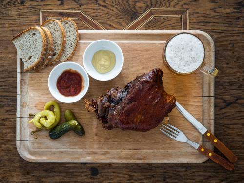 a cutting board with a piece of meat and bread at Zámeček Waldsteinovo Zátiší in Svatoslav