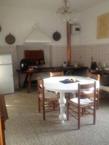 a kitchen with a white table and chairs in a room at alloggio turistico La Stalla in Tuscania