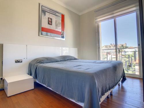 um quarto com uma cama e uma grande janela em Beach Penthouse with unique rooftop terrace 301 em Cannes