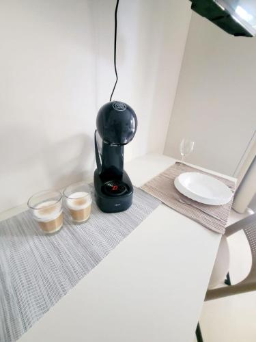 a coffee maker sitting on a table with two cups at Garden apartment Brno center in Brno