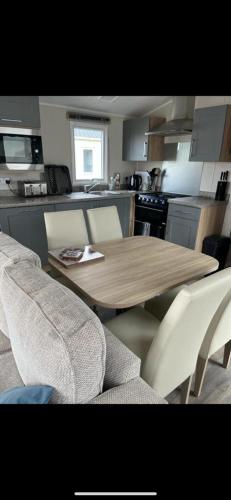 a kitchen with a wooden table and two chairs at White tower holiday park in Caernarfon