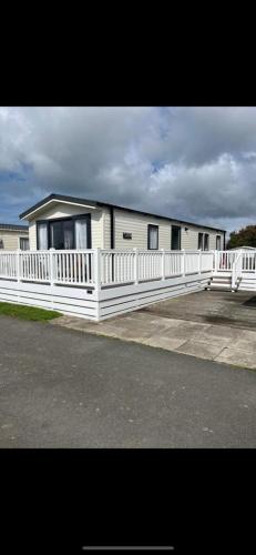 a white house with a white fence in front of it at White tower holiday park in Caernarfon