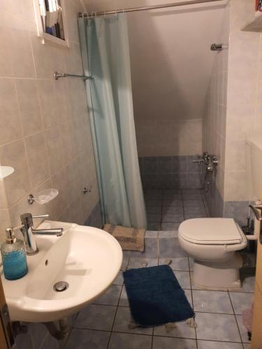 a bathroom with a sink and a toilet and a shower at Σπίτι με θέα in Nafpaktos