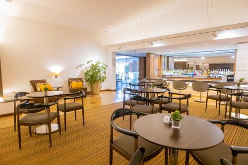 a restaurant with tables and chairs and a bar at Hotel JP Ribeirão Preto Resort & Convenções by Nacional Inn in Ribeirão Preto