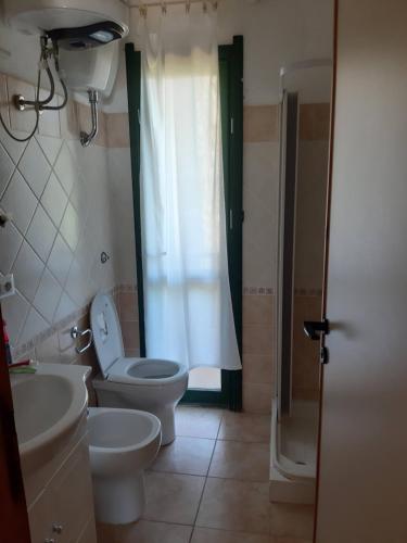 a bathroom with a toilet and a sink at Stintino - Cala Lupo in Stintino